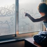 Back,View,Of,Little,Child,Handrawning,On,Fogged,Glass,Looking