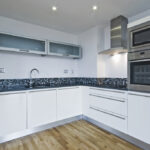 Contemporary,White,Kitchen,With,Built,In,Appliances,And,Mosaic,Tiles
